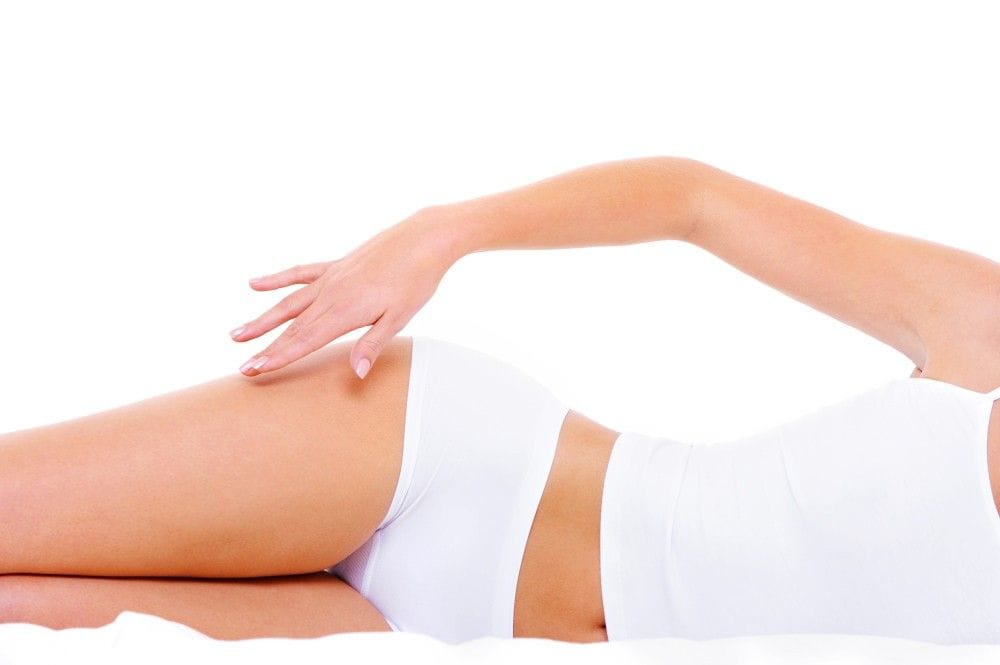 A woman lying on her side, showcasing thigh and buttock area, emphasizing cellulite treatment option.