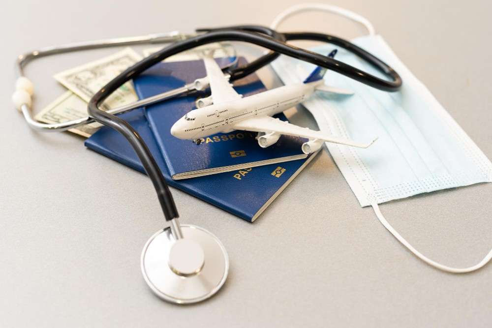 Medical travel essentials with airplane, stethoscope, passport, and masks.
