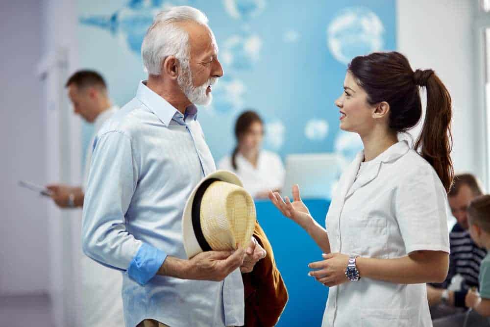 Friendly doctor discussing treatment options with senior patient in clinic.