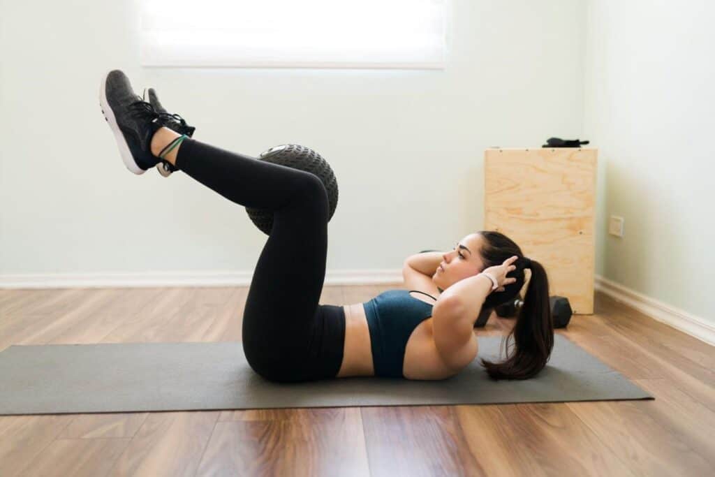 Woman doing abdominal exercise for belly fat loss at home.