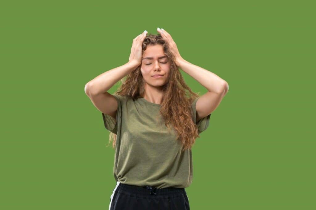 Woman holding head in frustration, struggling with belly fat.