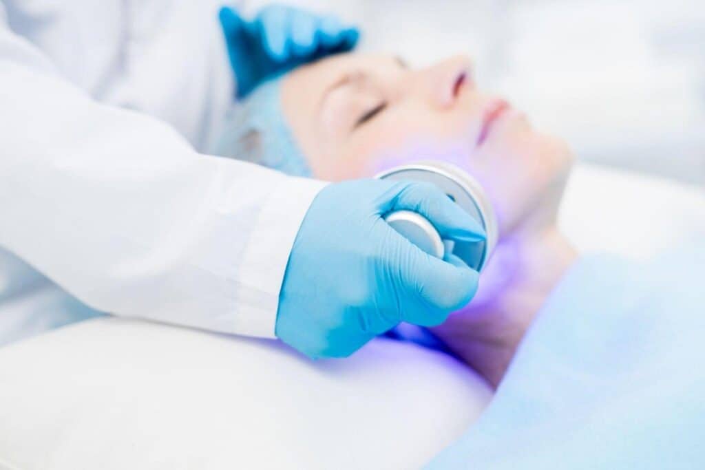 Woman receiving anti-aging facial treatment in Albania clinic.