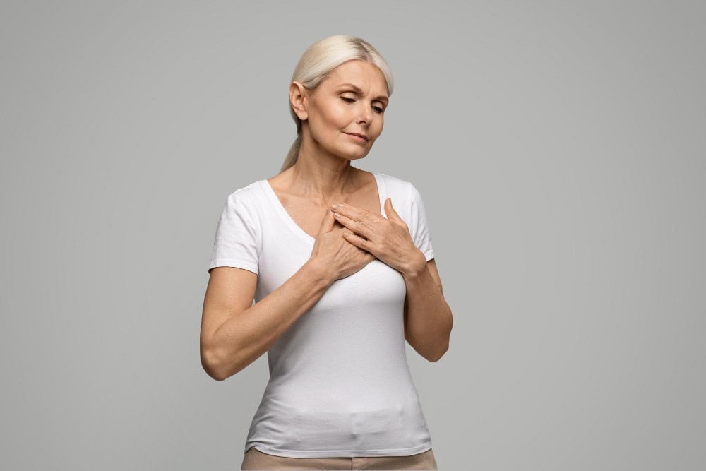 Mature woman considering breast augmentation, healthcare concept.