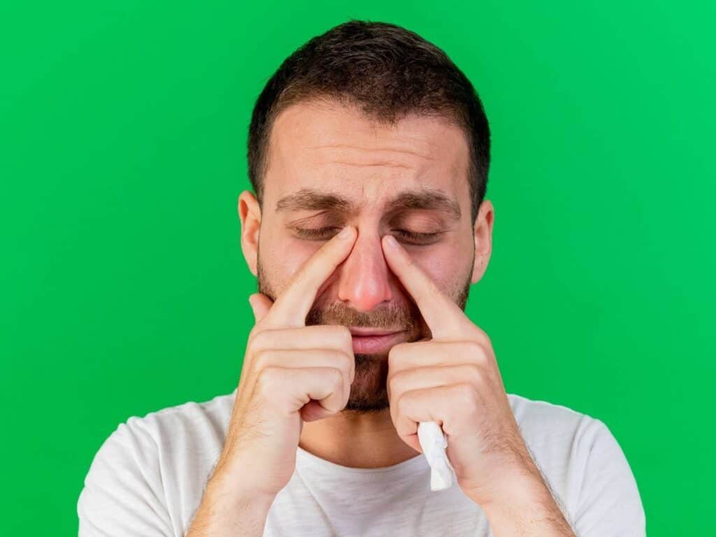 Homme ressentant une douleur au nez après une rhinoplastie en Albanie.