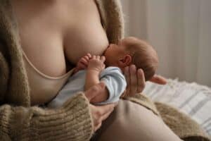 Mother breastfeeding her baby after pregnancy recovery.