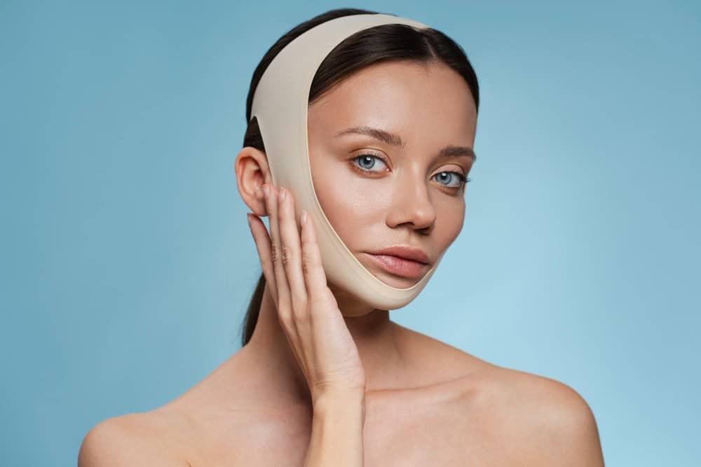 Belle femme avec un appareil de soutien facial, présentant les options de lifting.