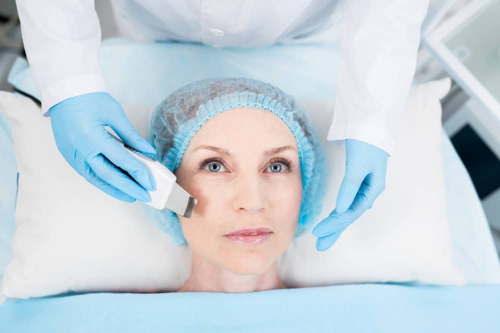 Femme recevant un rajeunissement profond de la peau avec un peeling à l'huile de phénol-croton dans une clinique.
