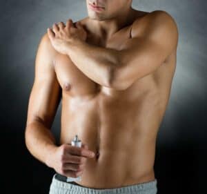 Hombre aplicándose crema de contorno corporal, tratamiento de modelado corporal masculino en Albania.
