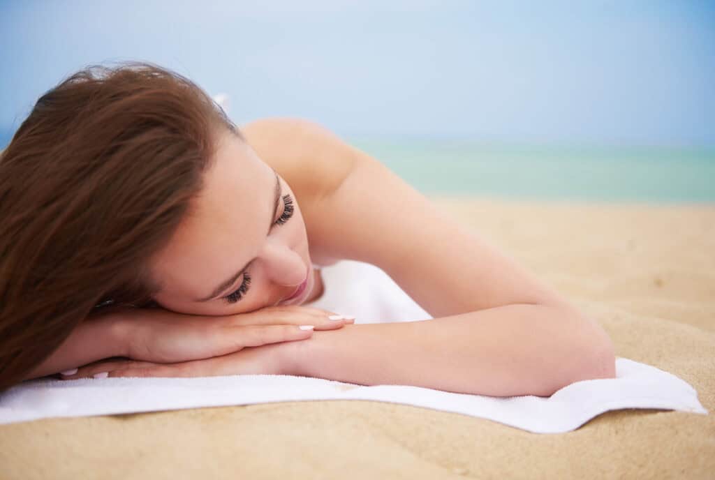Femme détendue sur la plage après un traitement médical en Albanie.