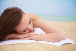 Ontspannende vrouw op het strand na medische behandeling in Albanië.