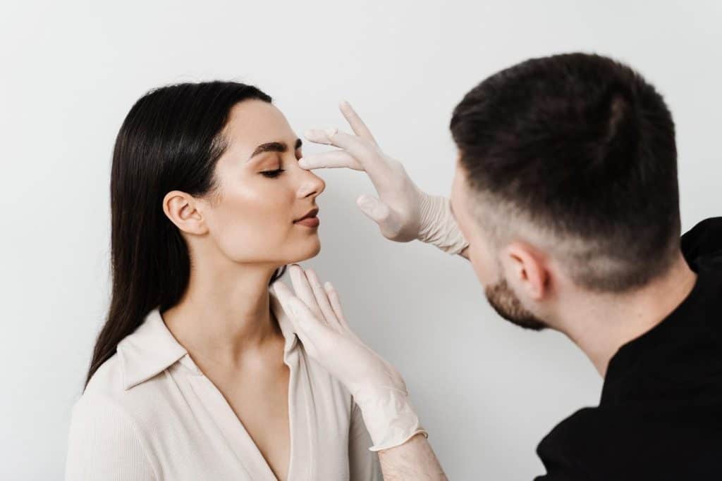 Chirurg voert een revisie-rhinoplastie uit bij een vrouw in Albanië voor een verbeterd neusuitzicht.
