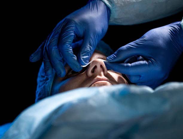Procédure médicale en Albanie avec des professionnels de santé portant des gants bleus.