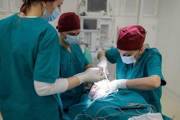 Χειρουργοί που εκτελούν χειρουργική επέμβαση σε αίθουσα χειρουργείου αλβανικού νοσοκομείου.