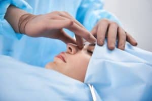 Medizinisches Fachpersonal führt eine Gesichtsbehandlung an einem Patienten in einer klinischen Umgebung durch.