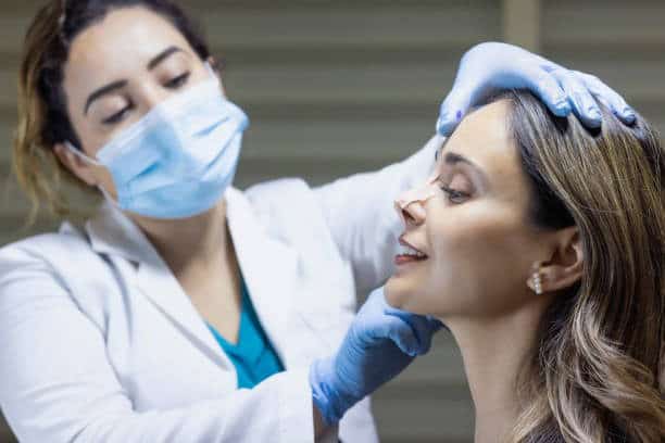 Un professionnel de la santé effectuant un examen facial sur un patient dans une clinique.