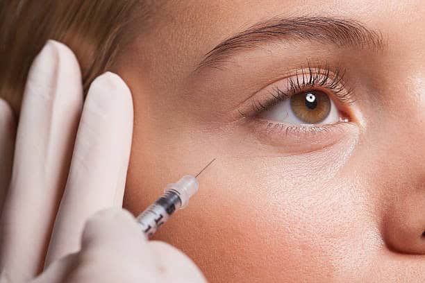Woman receiving a cosmetic injection for facial rejuvenation in Albania.