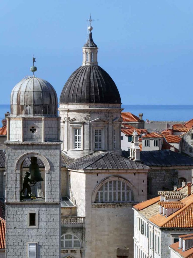 A view of the red rooftops and domeed roofs of the catheral from the Wall Walk around Dubrovnik Old Town. A complete guide to visiting Dubrovnik in 2 days. Included in this Dubrovnik 2 days itinerary are the top things to see in Dubrovnik. Learn everything about how to visit Dubrovnik in two days with this complete 2 days in Dubrovnik itinerary guide.