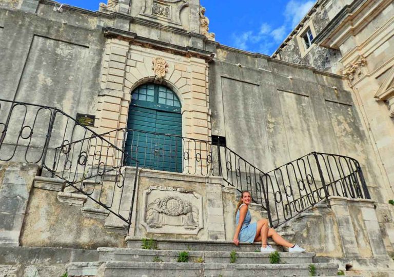 Old church with pretty stairs with me sat on the bottom step inside Dubrovnik Old Town