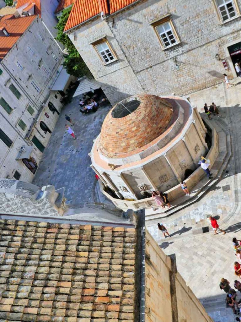 Looking down on the water fountain, red roofs and cobbled streets from the Old City Wall of Dubrovnik