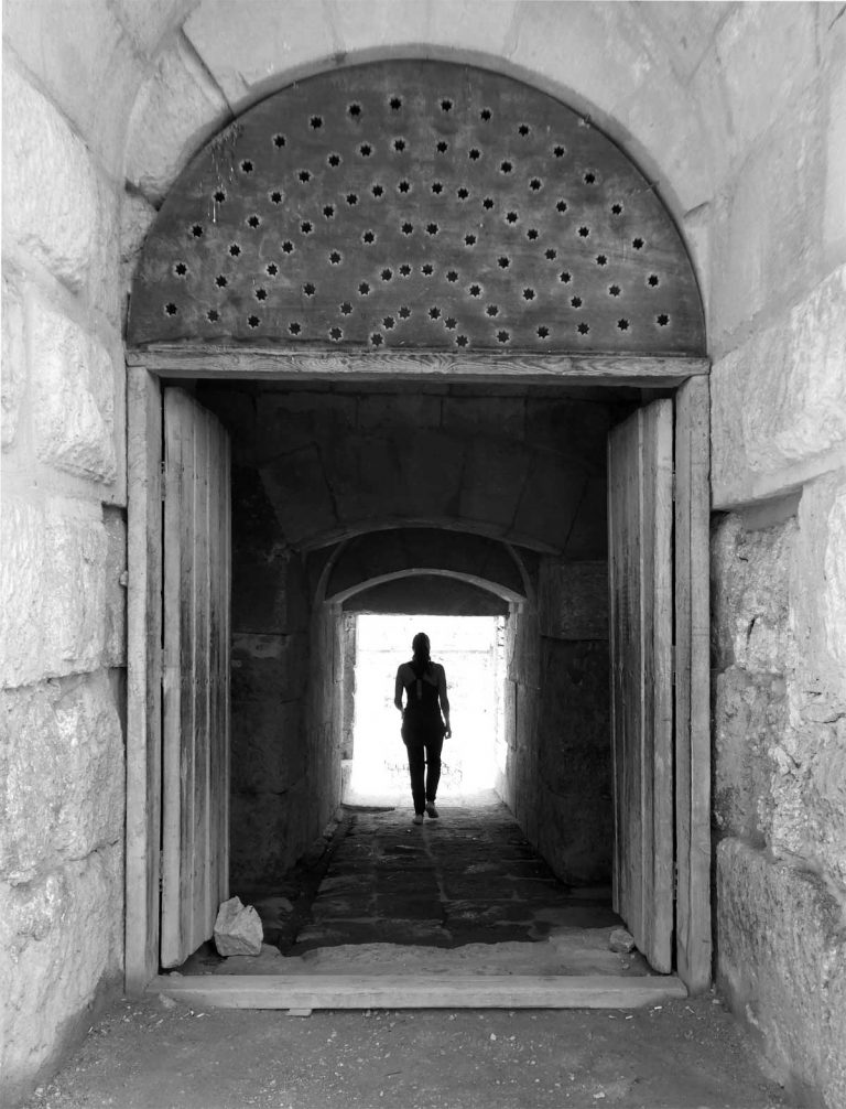 Entrance to the north theatre featuring a small tunnel with a woman walking at the center
