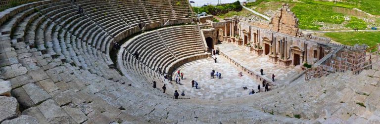 South Theatre in Jerash, Jordan, an open theatre on a semi-circular shape, with a front wall featuring a spacious staircase made of gray brick stone and still in use today.