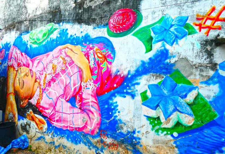A detailed mural on a side street just off Ratsada Road featuring a girl falling into the water but surrounded by local sweets, cakes and desserts. Created by an artist, simply known as Pin.