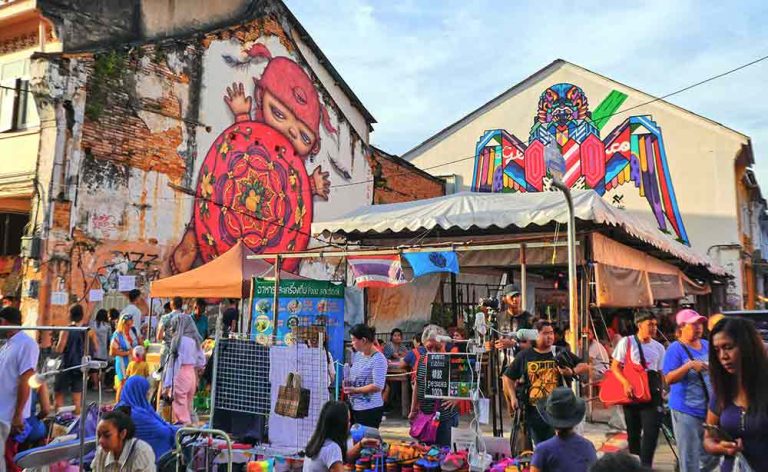 The main road is closed off for the evening/ night markets in Phuket Old Town with two of the iconic murals as a backdrop.