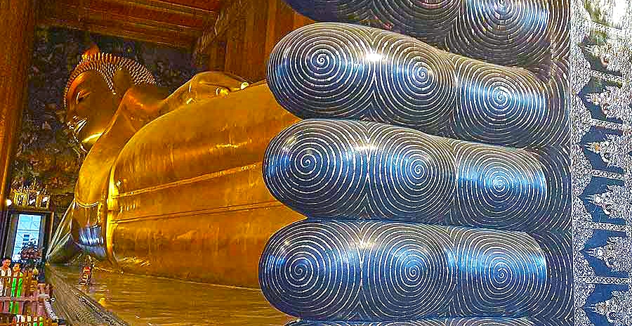 A giant reclining Buddha at Wat Pho with decorations of spirals on its feet. 