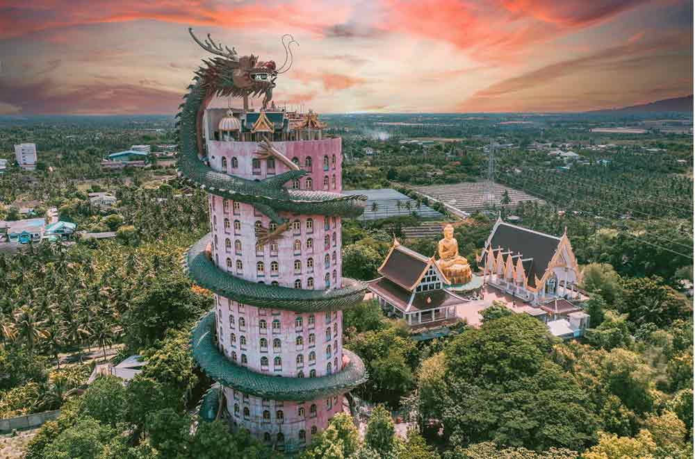 A pink cylindrical building with a dragon wrapped around it. 