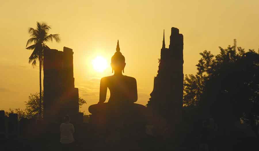Sukothai in Thailand showcases a silhouette of the grand statue of King Ramkhamhaeng the Great during sunset