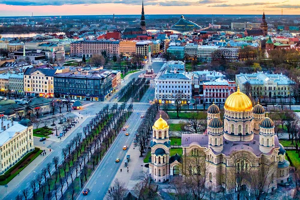 Best Riga 3 Days Itinerary: Exploring ‘Paris of the North’ 26 Riga skyline at dusk with a view of the Russian Orthodox Church in the forground. The church has a golden central dome.