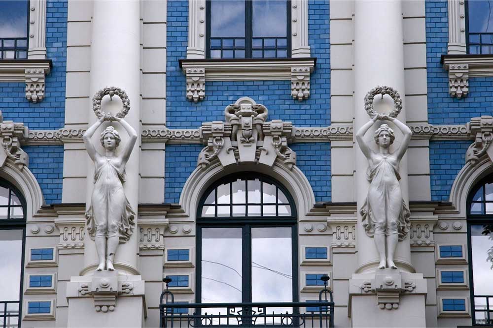 Best Riga 3 Days Itinerary: Exploring ‘Paris of the North’ 21 Art nouveau in Riga with an ornate blue bulding with statues of women on the outside.