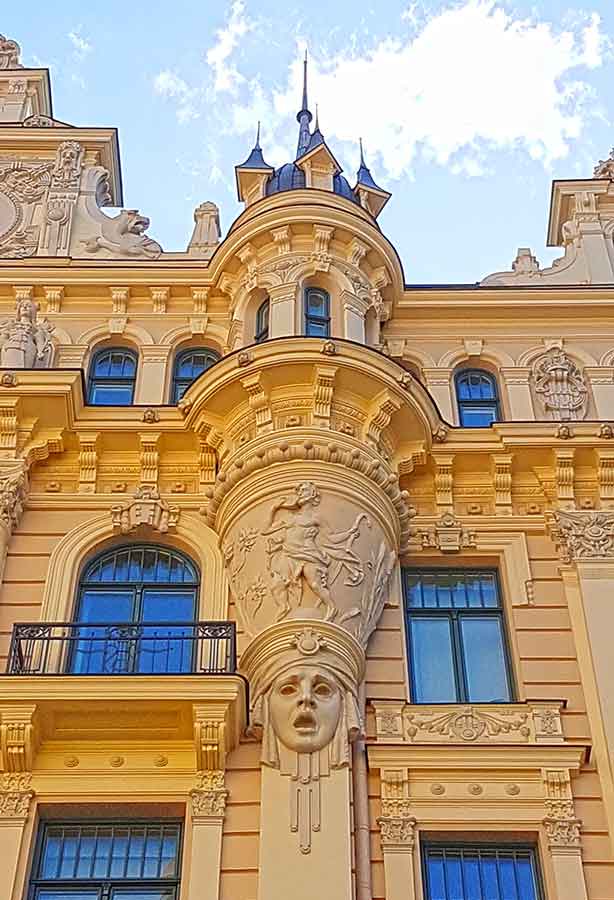 Best Riga 3 Days Itinerary: Exploring ‘Paris of the North’ 20 Building fascade in Riga with a womans face under a turret.