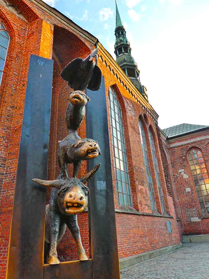 Best Riga 3 Days Itinerary: Exploring ‘Paris of the North’ 5 The Bremen Town musicians a statue of a cockeral standing on a cat, standing on a dog, standing on a donkey.