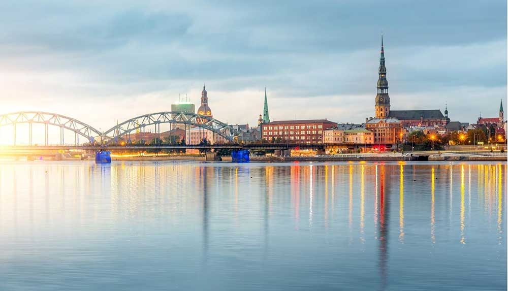 Best Riga 3 Days Itinerary: Exploring ‘Paris of the North’ 2 View of Riga from the water with buildings and churches reflecting in the water.