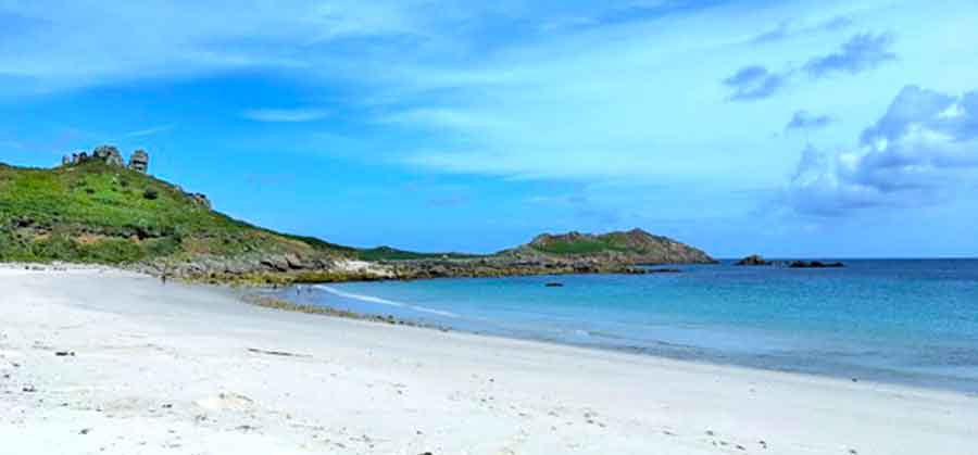 33 Best Hidden Coves and Secluded Beaches Around the World 22 Great Bay, Isles of Scilly, UK showcases its gray-white sand and a blue calm water on a clear blue sky