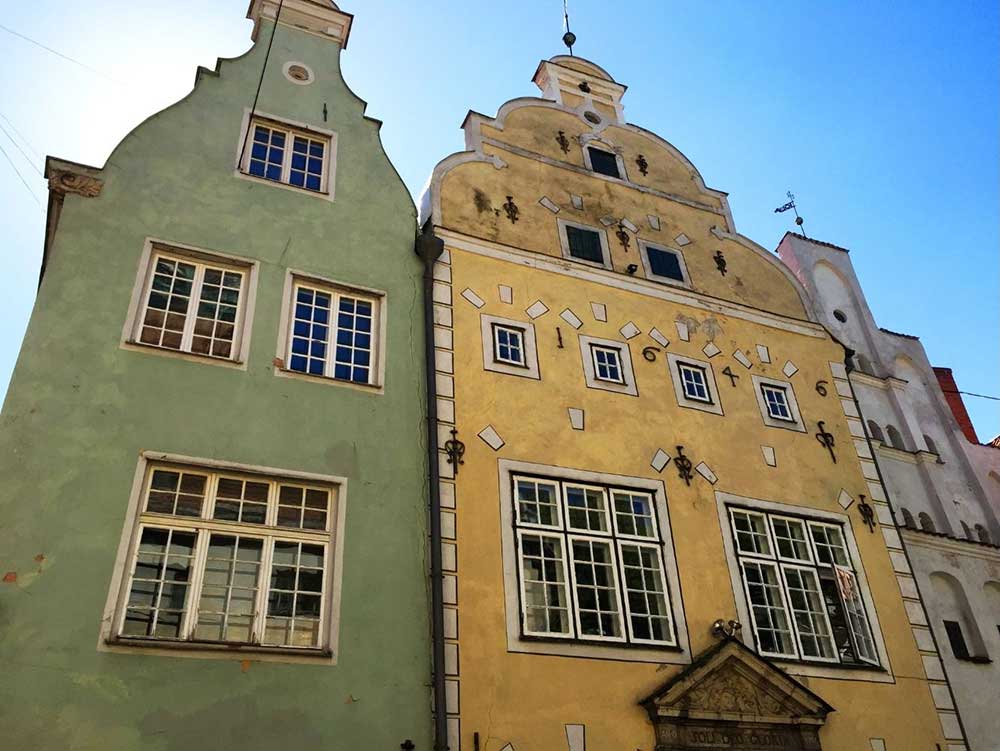 Best Riga 3 Days Itinerary: Exploring ‘Paris of the North’ 17 Three buldings stood side to side known as the three brothers. The building on the left is green, the one in the midle is yello and the one on the right is pinkish white.