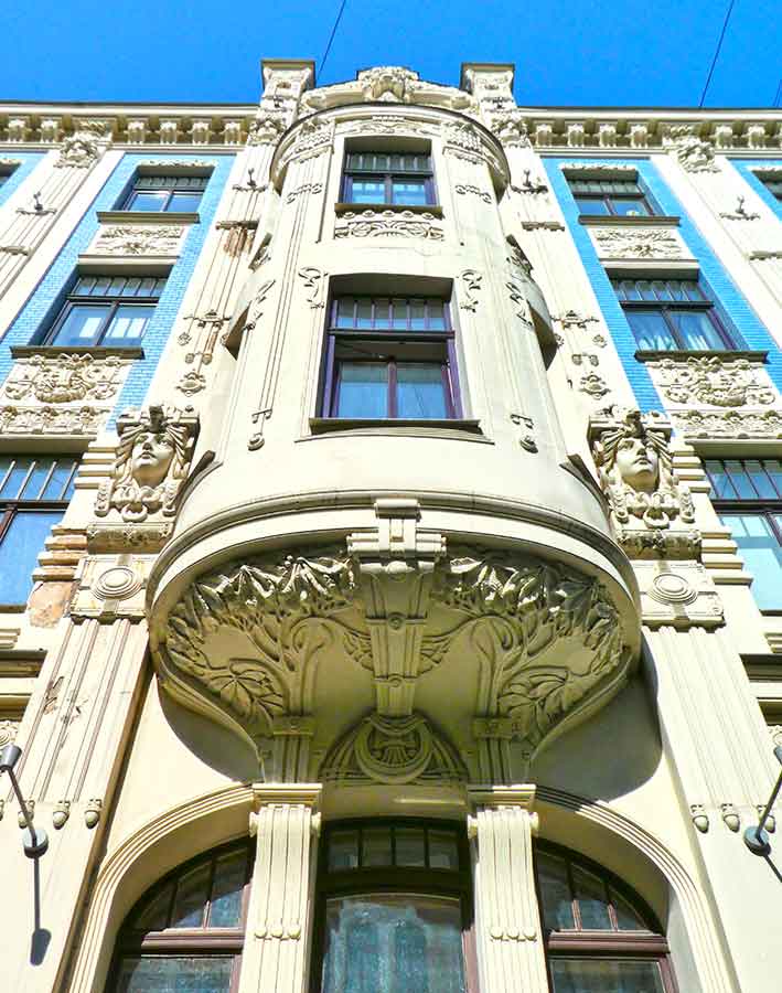 Where to See Art Nouveau in Riga, Latvia: Exploring The Art Nouveau District, Riga 3 Apartment building, Alberta Street 8 showcases carved faces and intricate details on the wall of the building