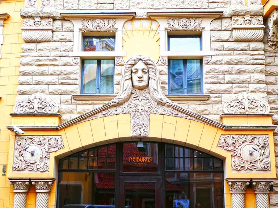 Where to See Art Nouveau in Riga, Latvia: Exploring The Art Nouveau District, Riga 16 Intricate carved ornaments and sad face like at the top of the Neiburgs Hotel Doorway