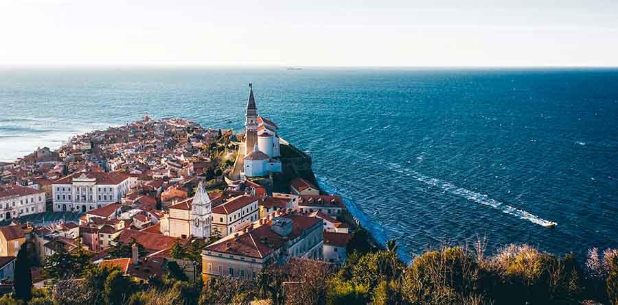 Aerial view of Piran featuring a blue sea and houses
