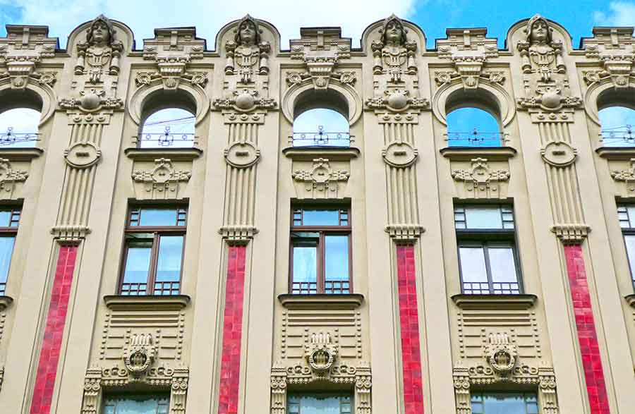 Where to See Art Nouveau in Riga, Latvia: Exploring The Art Nouveau District, Riga 7 The Boguslavskiy apartment building, Alberta Street 2a in Latvia with red tiles and intricate carvings of head, faces and patterns