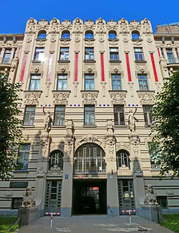 Where to See Art Nouveau in Riga, Latvia: Exploring The Art Nouveau District, Riga 4 Building at Riga, Latvia featuring a statue and carved intricate details on the wall with touch of cream-white color and red vertical