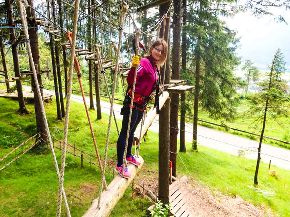 Extreme Adventures in Europe: 29 Best Adventure Sports in Europe 30 Young woman tried the climbing forest in Garmish-Partenkirchen, Germany with ropes among trees