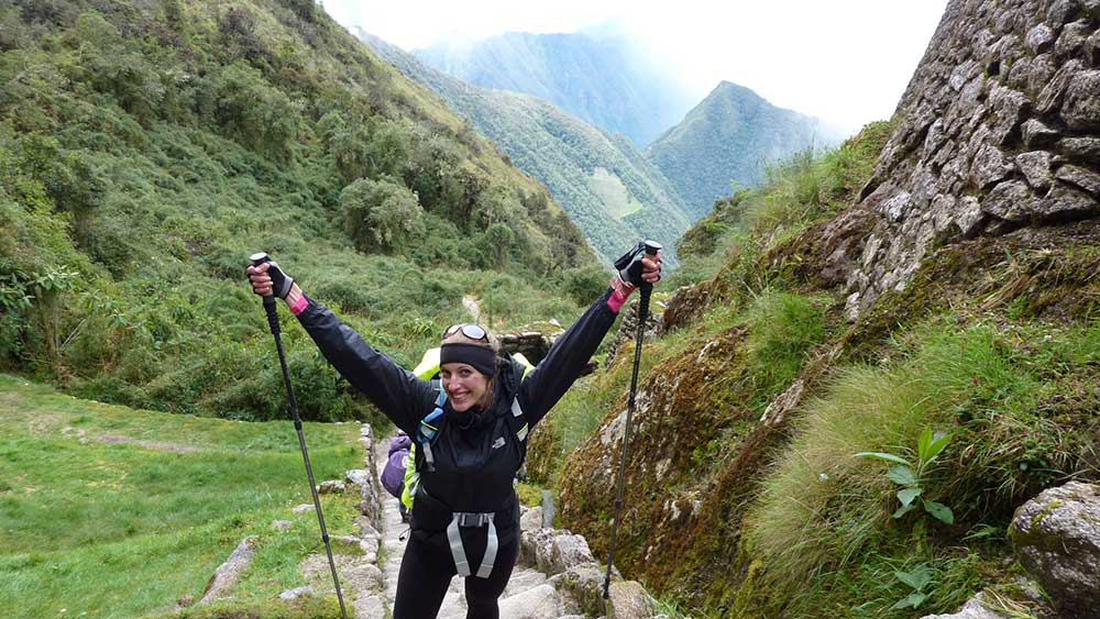G Adventures Inca Trail Review: What to Expect on The Inca Trail Trek to Machu Picchu 24 A woman (me) hiking with walking poles along the Inca Trail.
