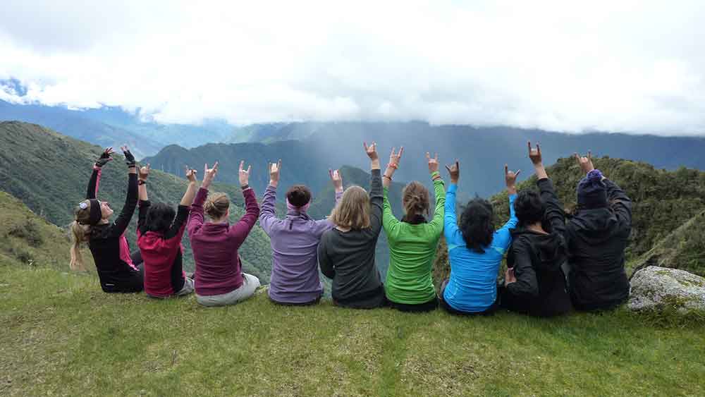 G Adventures Inca Trail Review: What to Expect on The Inca Trail Trek to Machu Picchu 25 Our group on the Inca Trail sat looking out over the mountain landscape with low lying clouds in the background.