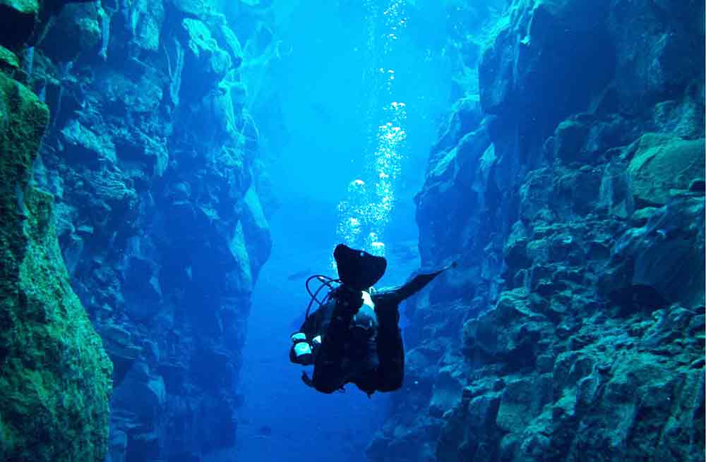 Extreme Adventures in Europe: 29 Best Adventure Sports in Europe 17 Diver at the middle tried the Scuba diving between the Tectonic Plates in Silfra Iceland