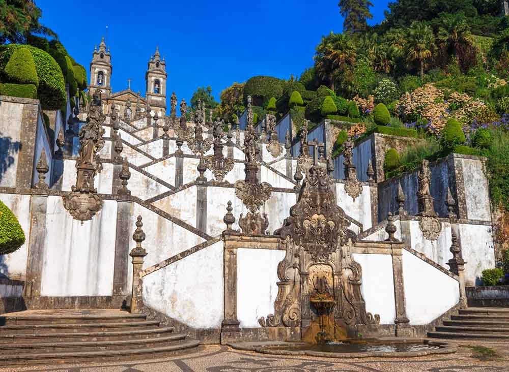 Bom Jesus do Monte in Braga features a church at the top with a grand staircase adorned with ornate balustrades and statues at various levels.