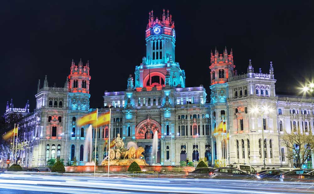 Madrid In Winter: Over 30 Things to Do In Winter in Madrid 9 Palacio de Cibeles inMAdrid illuminated with colourful fetive lights.