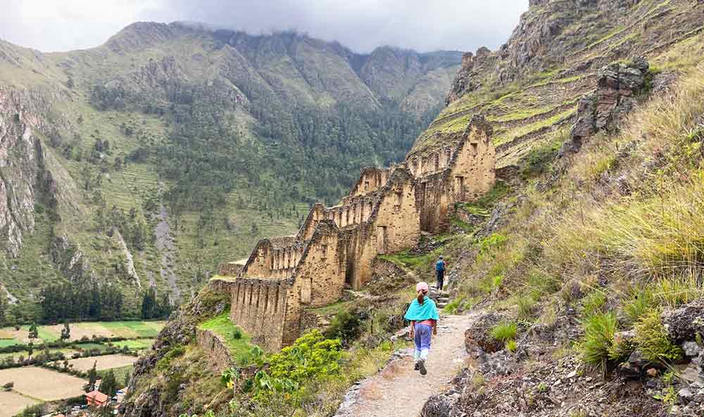 Pinkuylluna Ruins showing ancient farm buuildings sat on terraces on a hillside. 