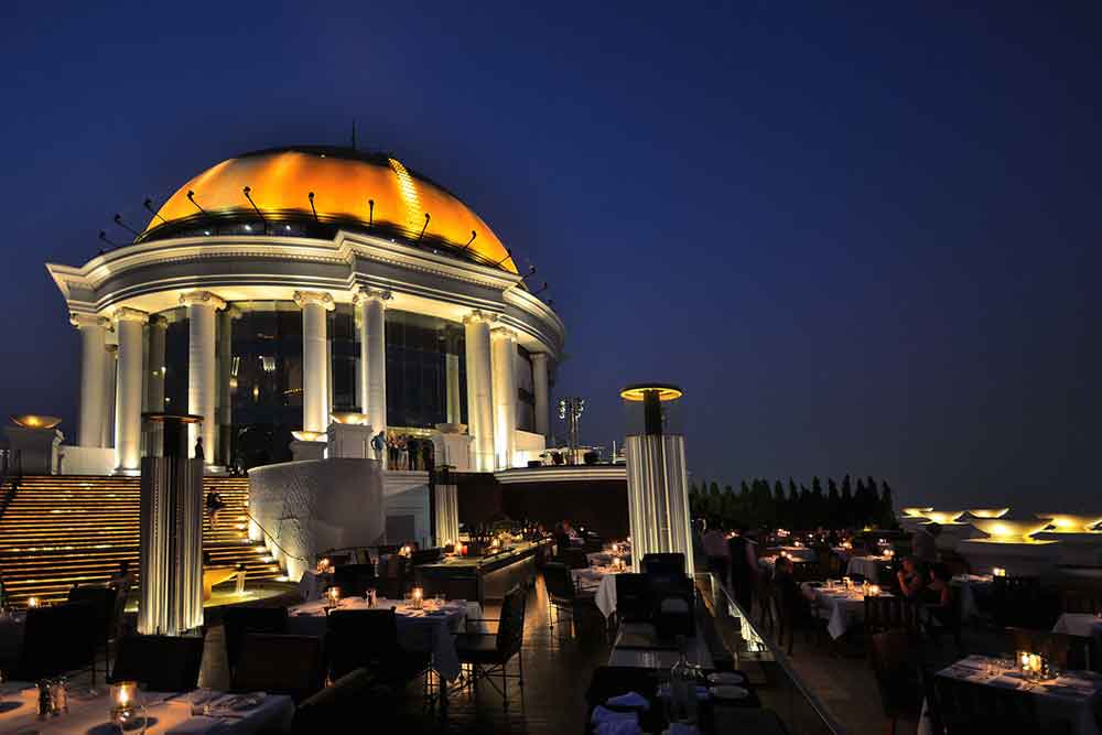 The roof of Lebua Sky Bar in Bangkok with tables and ambient lighting. 